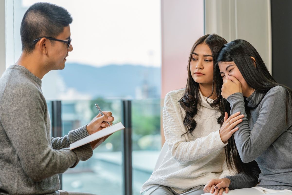 Asian male professional psychologist doctor giving the consult to Lesbian lovers patients which have relationship problem in modern living room of house or hospital exam room, Mental health Concept